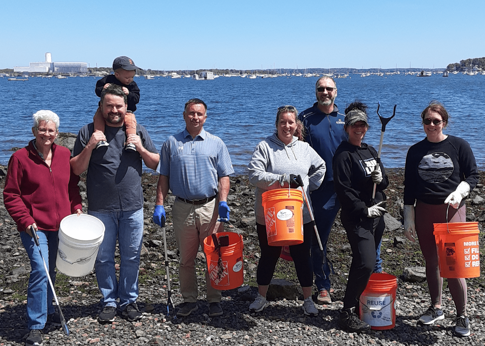 Group of volunteers pose for a photo at a beach cleanup in Salem, Massachusetts